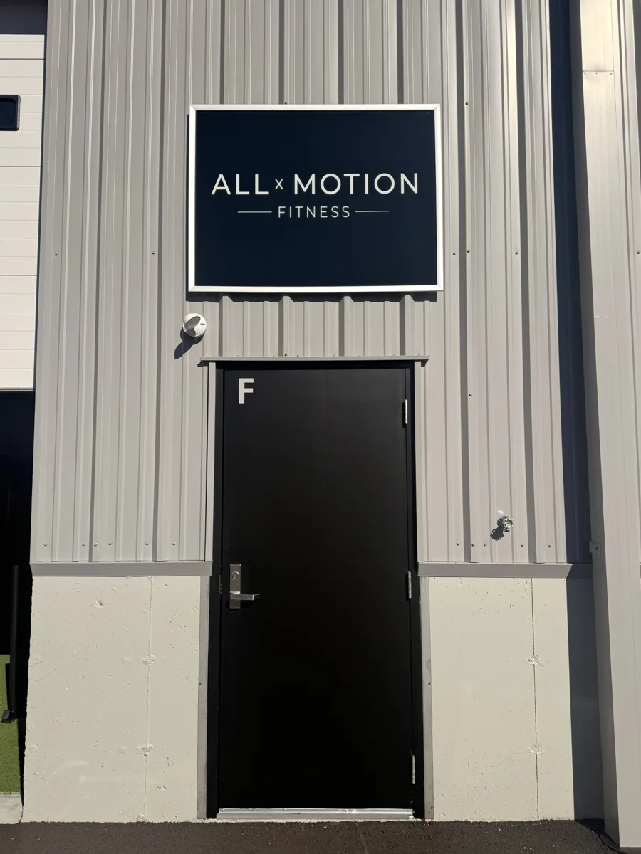 Outside All x Motion Fitness, Suite F, with the logo sign by the door